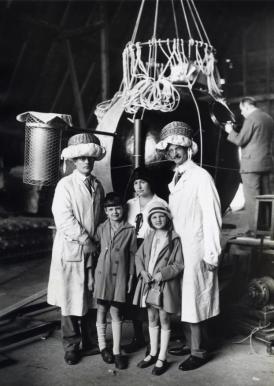 Professor Auguste Piccard (rechts vooraan) met zijn gezin en ingenieur Kipfer voor de capsule van de ballon waarmee een stratosfeervlucht gemaakt gaat worden. Op hun hoofd dragen de wetenschappers helmen gemaakt van naaimandjes en kussens. [27-05-1931]